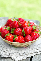 basket with strawberries on a garden wooden table