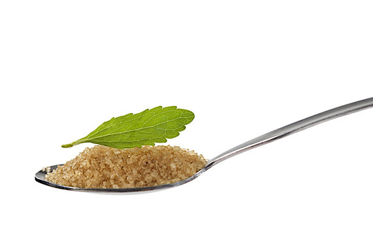 Stevia leaf with spoon of brown sugar