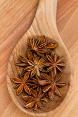 star anise in a spoon on wooden surface