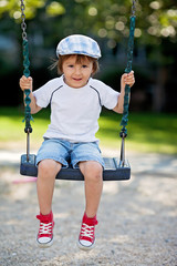 Cute boy, swinging on the playground