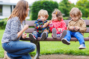 Fototapeta na wymiar Mother and her children in summer park
