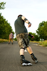 Fototapeta na wymiar Young man with inline skates in summer