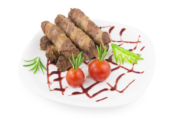 Fried meat rolls and bacon on a plate