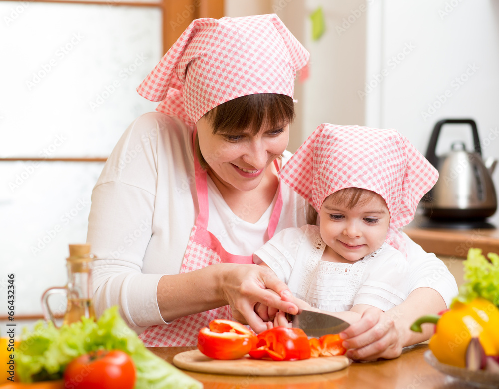 Wall mural mom and kid girl preparing healthy food