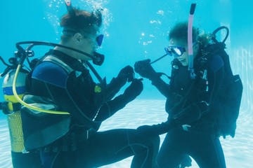 Man proposing marriage to his shocked girlfriend underwater in s © WavebreakmediaMicro