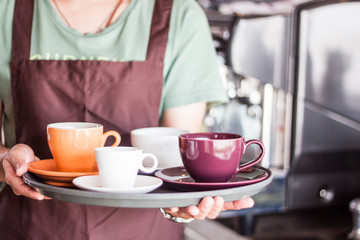 Coffee shop owner serving set of freshly brewed coffee