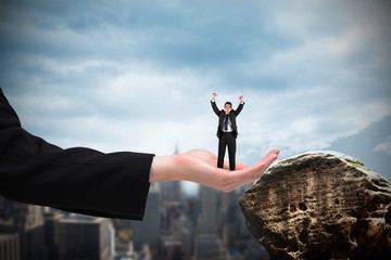 Composite image of businessman cheering at the camera in large h