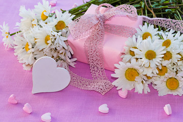 Margeriten und Geschenk auf rosa Untergrund, Textfreiraum © Sonja Calovini
