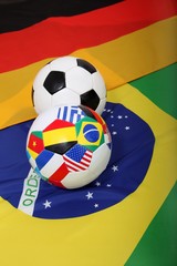 Obraz premium Fussbälle mit Flaggen auf Flagge von Brasilien und Deutschland