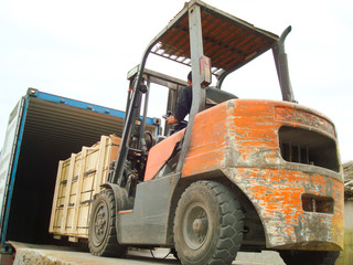 Electric Forklift Loading Cargos into Container