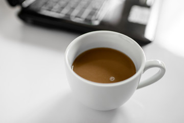 Coffee cup and laptop for business, Selective focus on coffee.