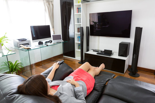 Business Young Woman Watching TV In Modern Home Office With Comp