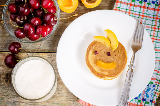 breakfast with fresh pancakes with cherries and apricots for kid
