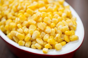 Close-up of sweet corn kernels in a glass bowl, studio shot