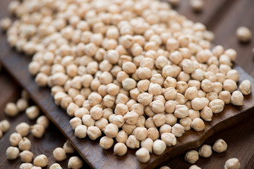 Raw chickpeas over wooden background, close-up, studio shot