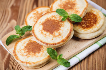 Wooden cutting board with homemade fritters, horizontal shot