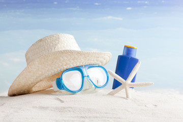 Straw hat,  snorkel mask and flip flops on a tropical beach 
