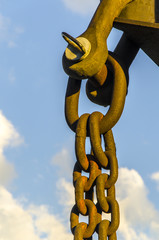 Stahlkette mit Haken am Himmel mit Wolken