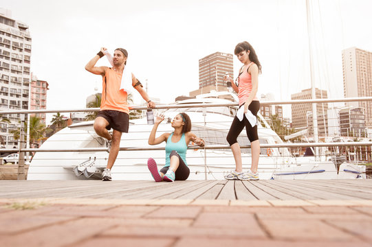 Mixed Group Of Runners Sharing A Water Break After Exercise