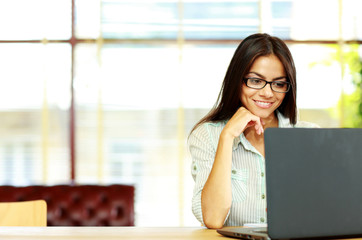 Smiling businesswoman working on the laptop at office