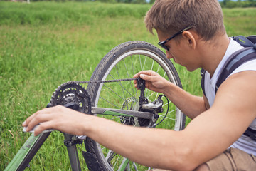 Obraz premium Cyclist checks chain