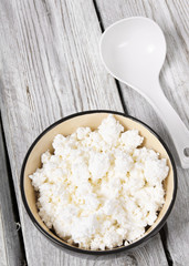 Cottage cheese on wooden board .