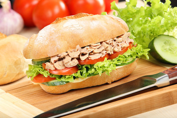 Sandwich with tuna and tomato on wood background