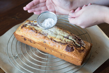 Puderzucker auf Marmorkuchen auftragen