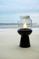 candle lights up a table. Romantic dinner by the sea