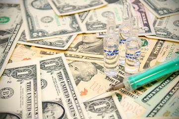 Syringe, tablet on money.