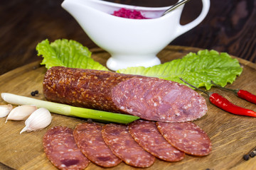 sausages on a wooden plate with vegetables in a restaurant