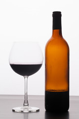 Glass and a bottle of red wine isolated on white background