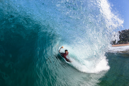 Surfing Body-Boarder Rides Inside Hollow Blue Wave