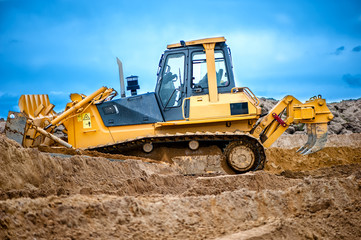 bulldozer or excavator working with soil on construction site