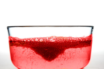 Liquid soap pouring into Glass container of Water