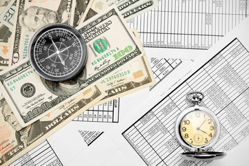 Compass , watch and money (dollars). On documents.