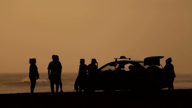 Freunde am Strand im Sonnenuntergang