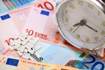 Alarm clock and tablets for euro banknotes.