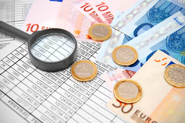 Euros of a banknote and a coin on documents.