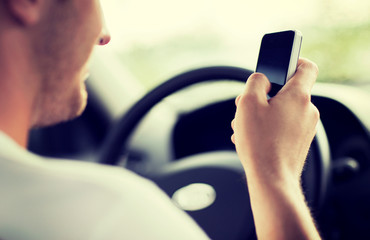 man using phone while driving the car
