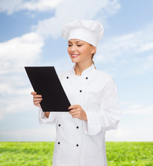 smiling female chef with black blank paper