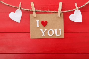 I Love You message card over red wooden board