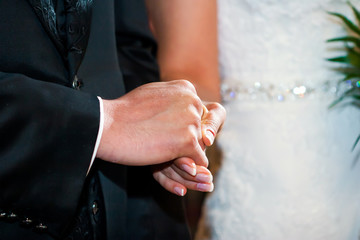 Couple holding hands at wedding ceremony