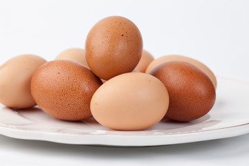 Platter of freshly collected brown eggs on a white background 