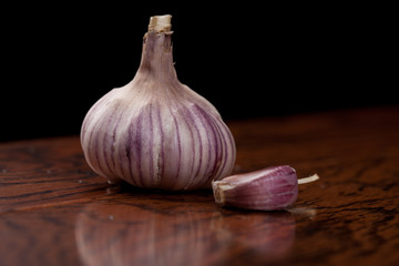 California grown organic Russian Red Garlic bulb and clove on a black background