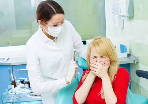 Young patient in dentist office, afraid of anesthetic injection