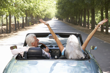 Senior couple in sports car - obrazy, fototapety, plakaty