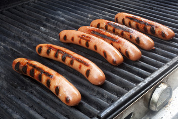 Hot dogs cooking on a grill