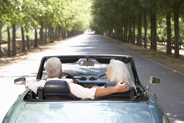 Senior couple in sports car - obrazy, fototapety, plakaty