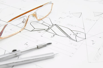 Glasses and compasses on drawing.